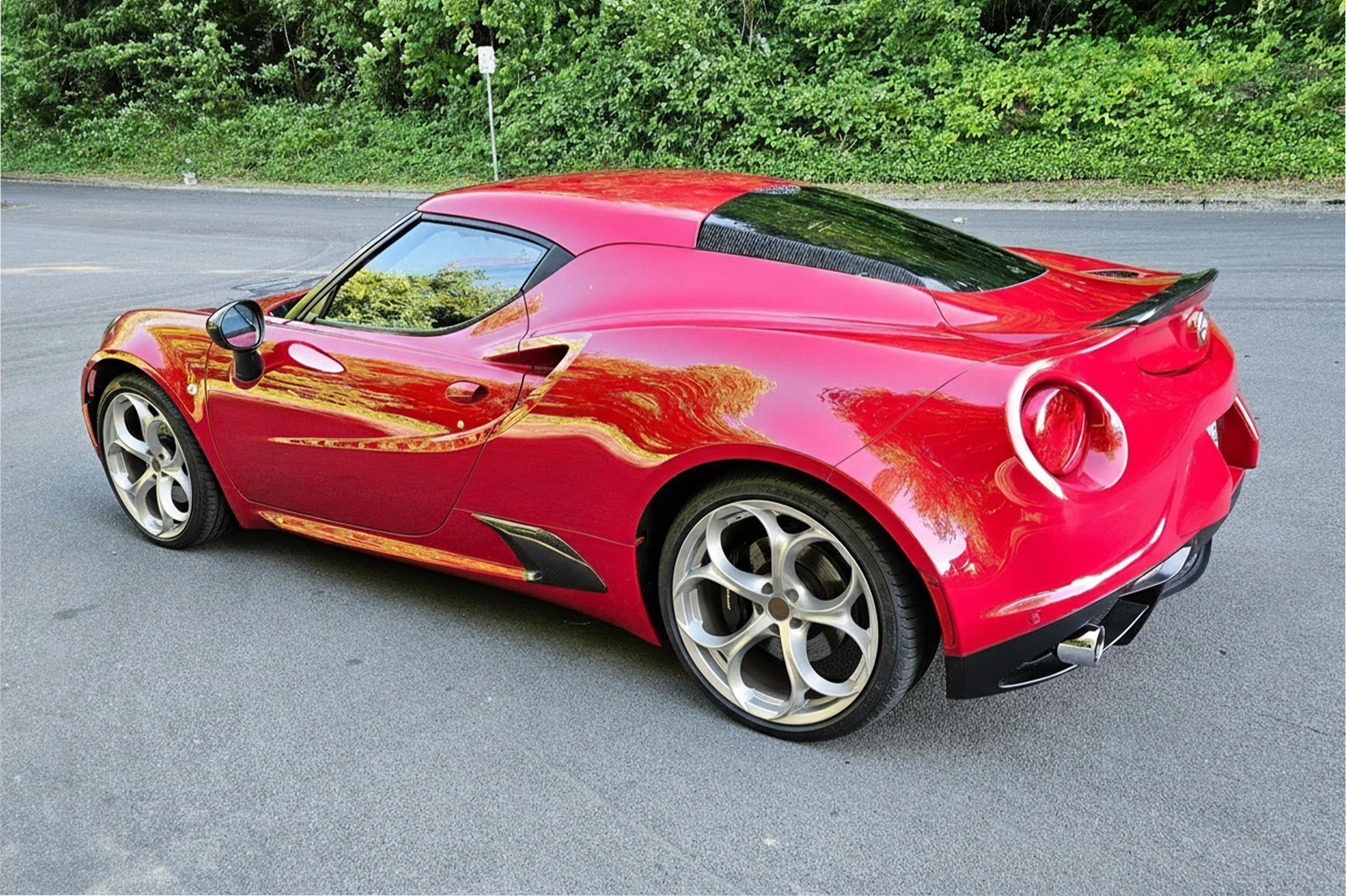 Red Alfa Romeo 4C rear three‑quarter parked on a quiet road